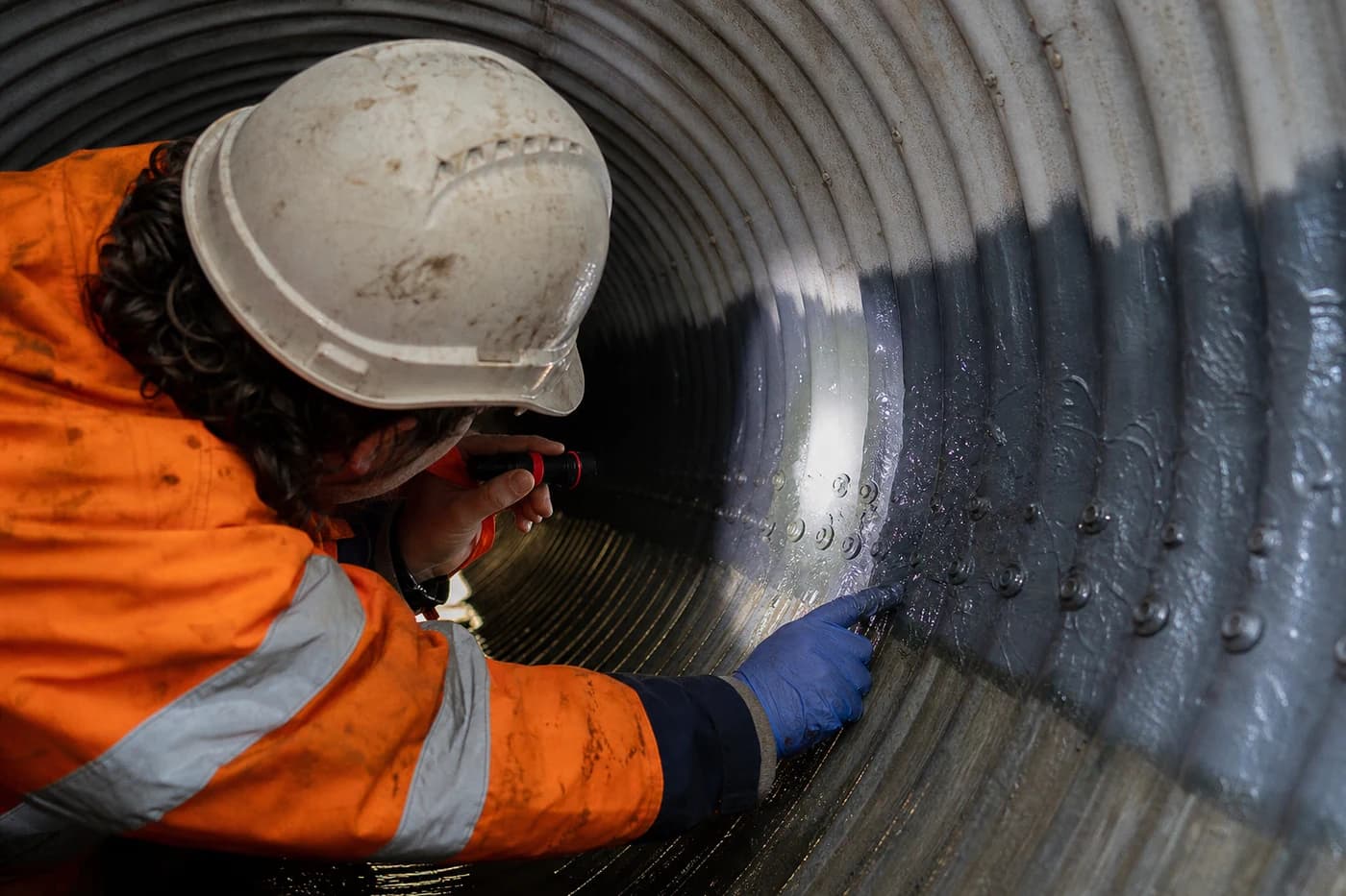 Close detail of pipe culvert interior during culvert remediation with lining repair and joint seal inspection