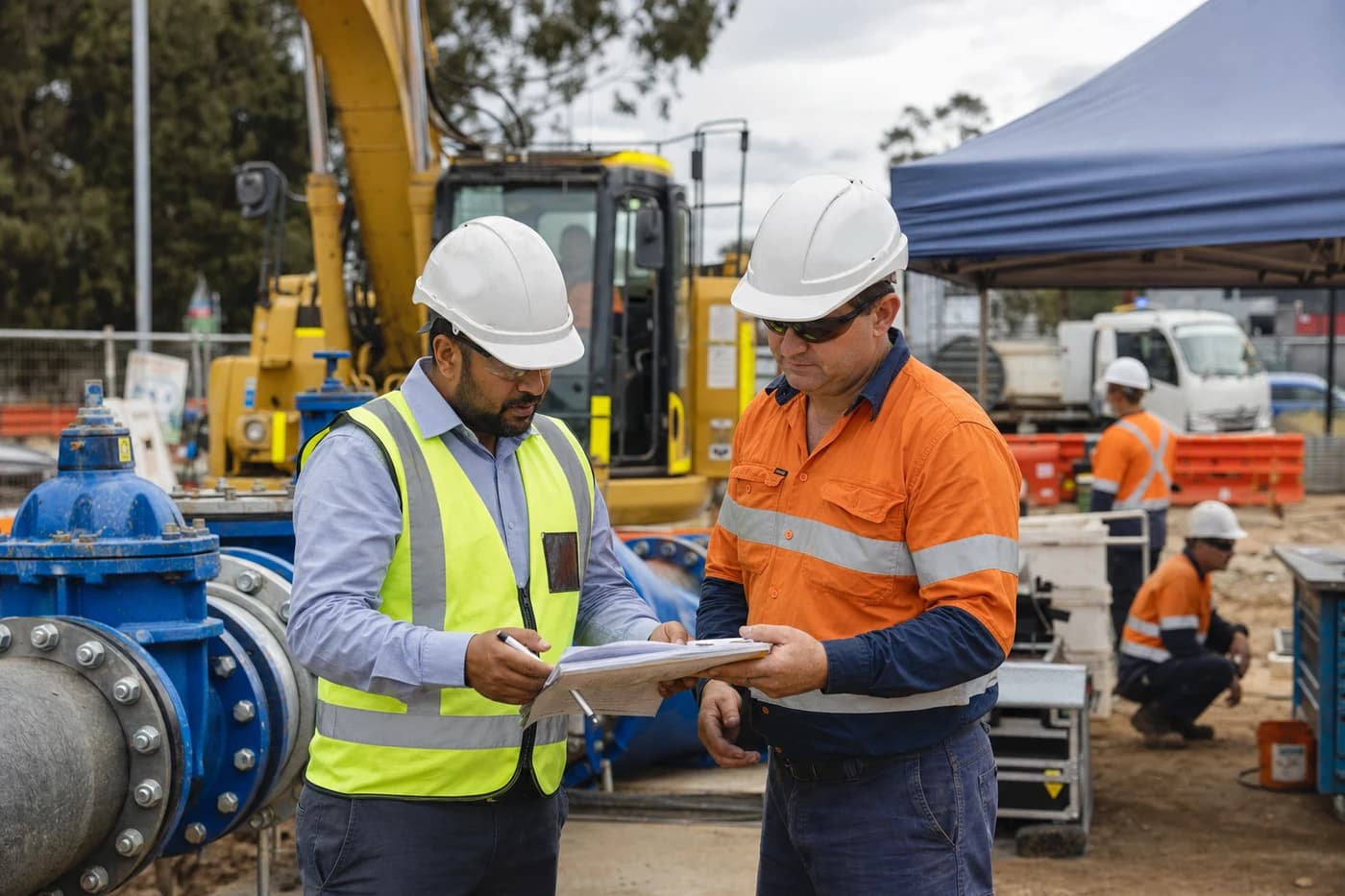 Authority inspector and site manager reviewing inspection checklist at Sydney Water listed provider live network works hold point