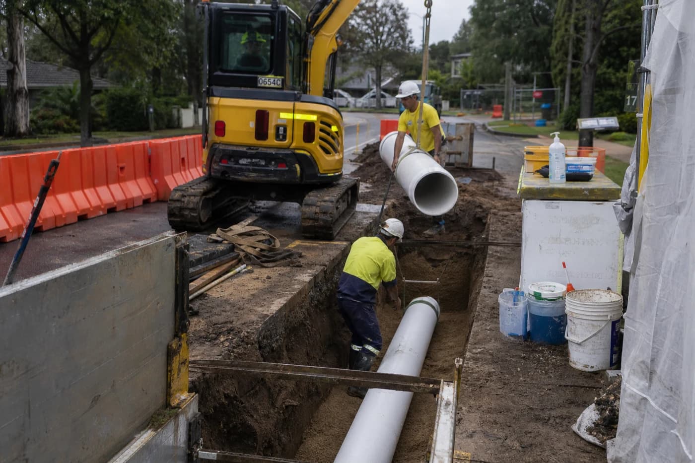 Field crew installing PVC sewer main section during sewer main rehabilitation in a prepared trench on an NSW renewal programme